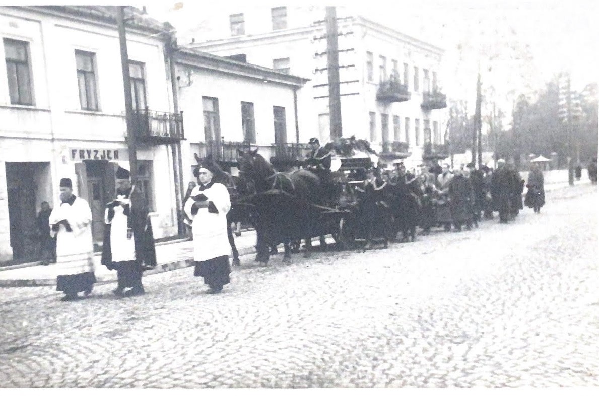 Na czarno białym zdjęciu widać kondukt żałobny. 